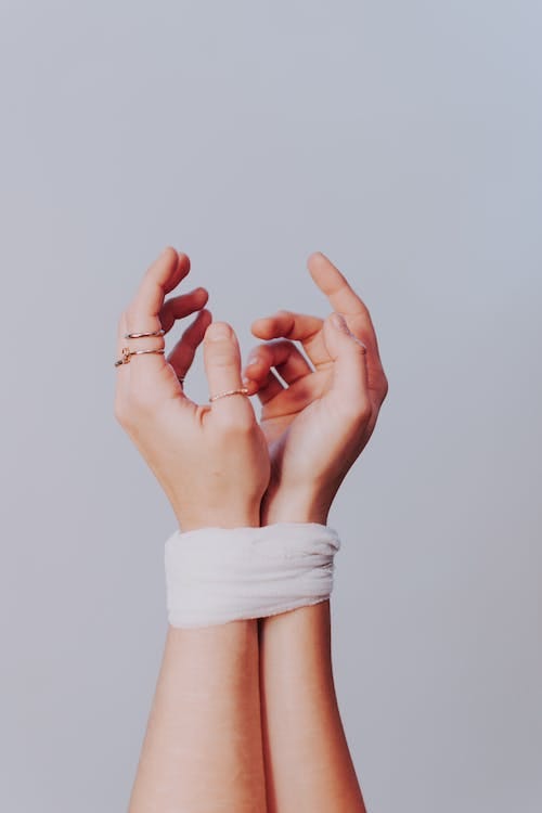 ungendered hands, bound by a tape to represent the stifling nature of generational trauma